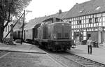 Am 19.5.1981 eskortiert der Zugbegleiter höchstpersönlich seinen Nahverkehrszug von Hellenthal nach Kall, geführt von 211 087, durch die markante Ortsdurchfahrt von Olef.