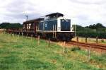 Die oceanblau-beige 212 006-1 mit eine Gterzug zwischen Flensburg und Kiel bei Sderbrarup am 28-7-1992.