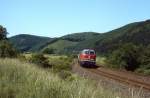 An einem Frühsommertag 1982 ist 215 042-3 aus Richtung Trier kommend kurz vor Gerolstein unterwegs