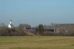 RE 57512 von Mnchen nach Fssen, bespannt vermutlich mit 218 488, auf der Lechbrcke in Kaufering. Im Hintegrund die Wallfahrtskirche St. Leonhard. 14.03.2012