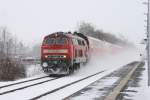 218 443 fhrt mit 4 Dosto als IRE4225 durch Friedrichshafen Flughafen nach Lindau, nchster Halt wird Friedrichshafen Stadt sein, aufgenommen bei Schneegestber am 11.12.2012
