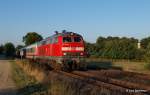 218 321-8 passiert in den ersten Sonnenstrahlen des 06.09.13 mit der Leergarnitur des IC 2327 Ratekau auf dem Weg nach Fehmarn/Burg.