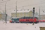 08. Januar 2000 im Bahnhof Freilassing: Lok 218 358 fährt bei heftigem Schneetreiben mit einem Meininger Schneepflug in Richtung Mühldorf aus.