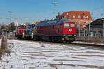 TLVG 233 217 in weineroter Lackierung (ex DR 132 217) steht am 14.02.2021 mit zwei V 60 dieses Unternehmens auf dem Abstellgelände gegenüber dem Bf. Mannheim-Rheinau.