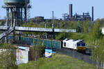 Die Diesellokomotive 247 020-1 zieht einen Leerzug durch den eingezäunten Gleisbereich im Rheinpark Duisburg-Hochfeld.