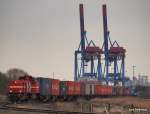 Vor der Imposanten Hafenkulisse Altenwerders schiebt MaK G 1000 BB DH711 der HGK einen Containerzug aus dem Rbf Alte Sderelbe in den Containerterminal Altenwerder. 27.02.10.