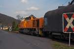 Lok 44 (MaK G 1000 BB) der Kreisbahn Siegen-Wittgenstein (KSW) fhrt, auf KSW eigenem Gleis, mit vollem Gterzug am 25.03.2011 in Neunkirchen-Struthtten ber den Bahnbergang Fllstrae in Richtung