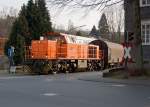 Lok 44 (MaK G 1000 BB) der Kreisbahn Siegen-Wittgenstein (KSW) fhrt, auf KSW eigenem Gleis, mit vollem Gterzug am 25.03.2011 in Neunkirchen ber den Bahnbergang Wiesenstrae in Richtung