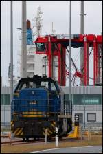 evb V 2302 wartet hier am Jade-Weser-Port auf sein Containerzug der gerade in der KV-Anlage abgefertigt wird.Im Hintergrund sind noch einige van carrier und  das havarierte Containerschiff  Purple