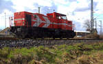 DE91 von Rheincargo steht mit Licht an im Güterbahnhof von Nievenheim. Aufgenommen vom einem Weg am Kirschfeld in Nievenheim. 
Bei Sonnenschein und Regenwolken am Nachmittag vom 31.3.2018.