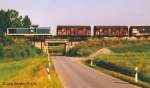 Blick nach Westen auf den Gterzug auf der Brcke ber die Strae zum Feuchtwangener Stadtteil Kaltenbronn. (27.6.94)