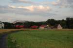 294 750 bringt im letzten Abendlicht ihren Gterzug am 07.07.2008 nach Amberg, hier am Ortsrand von Hirschau.