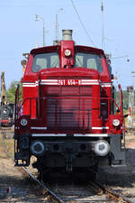 Die 1959 bei MaK gebaute Diesellokomotive 261 654-8 ist mit zwei Prsonenwagen in Darmstadt-Kranichstein unterwegs. (September 2019)