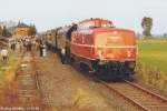 Blick nach Osten auf V 80 002 im Bahnhof Steppach-Pommersfelden am 14.10.1984. Die mitfahrenden Eisenbahnfans begutachten beim Fotohalt die historische Zuggarnitur.