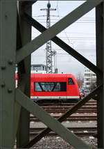 Die Verwandschaft von Zug und Masten -    Fachwerkkonstruktionen vor dem Zug, hinter dem Zug, im Zug gespiegelt und auch der Zug selbst.