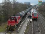 Während an der Haltestelle Ulm-Donautal Fahrgäste in den 611 032 einsteigen, der als RB 22620 von Aulendorf nach Ulm Hbf unterwegs ist, stellt hinter dem Bahnsteig V 150 der Hohenzollerischen Landesbahn leere Kesselwagen zu einem Zug zusammen (24.03.2014).