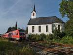Unmittelbar nach der Abfahrt im Bahnhof passiert 612 020 als RE 3992 von Lindau nach Ulm die Kirche von Oberstaufen (07.09.2014).