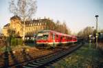 LVT 628 592-8 durchfhrt an einem Mrzabend 2005 den Haltepunkt Chemnitz/Borna. Im Hintergrund das markante Gebude der ehemaligen  Knopffabrik .