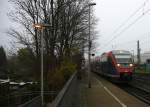 Die Euregiobahn (RB20) aus Heerlen(NL)-Stolberg-Hbf kommt die Kohlscheider-Rampe hoch aus Richtung Herzogenrath und hält in Kohlscheid und fährt in Richtung Richterich,Laurensberg,Aachen-West. 
Bei Nebelwolken an einem Kalten am Vormittag vom 3.12.2014.