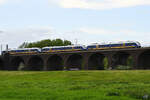 Drei gekoppelte Dieseltriebzüge der NordWestBahn befahren Anfang Mai 2021 die Hochfelder Eisenbahnbrücke in Duisburg.