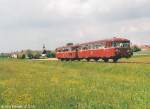 796 724 und 996 773 sind am 21.5.95 auf dem Weg nach Osten in Wachenroth abgefahren. Im Hintergrund sieht man die Silhouette des 2000-Einwohner-Marktes mit dem Kirchturm.