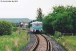 772 120 hat gerade Frttstdt verlassen, dessen Bahnhofsgebude man im Hintergrund sieht, und fhrt am Einfahrsignal vorbei.