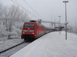 101 111 durchfhrt mit IC 2213 den verschneiten Bahnhof Stralsund-Rgendamm.