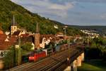 Am Abend des 30. August 2019 passierte 152 053 mit dem Audi-Logistikzug GA 60064 von Ingolstadt Nord nach Braunschweig Rbf die Altstadt von Gemünden am Main. Gut zu erkennen: die zur ehemaligen Stadtbefestigung gehörenden zwei Wehrtürme (Eulenturm und Hexenturm) sowie die Stadtpfarrkirche St. Peter und Paul in gotischem Baustil.