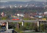 Eisenbahnviadukt Stuttgart-Münster -

Bild 2: Weiter geht die Verfolgung der 152 auf dem Eisenbahnviadukt Stuttgart-Münster. Unten ist ein Pfeilerrest des ursprünglichen 1896 erbauten Viadukts erkennbar, damals als Eisenfachwerkkonstruktion. 1985 wurde der alte Viadukt durch die neue Brücke ersetzt. Links wechselt die Tragkonstruktion aufgrund der größeren Spannweite über den Neckar zu einer Fachwerkkonstruktion. Im Hintergrund erkennbar der Neckar und der Rosensteinpark. Bei den Höhenzügen oben handelt es sich links um den Hasenberg und weiter rechts als höchste Erhebung um den Birkenkopf, einem Trümmerberg. 

09.04.2009 (M)