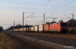 152 130-1 rollt im Streiflicht mit ihrem Containerzug durch Bardowick-Bruch Richtung Süden.