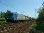 Eine 185 mit einem Gterzug am Haken hinter dem Kreuz Eichgestell am Bahnbergang Biesdorf.