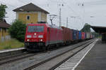 Lok 185 207 der DB Cargo durchfährt am 2. Juli 2021 um 8.15 Uhr den Bahnhof Übersee mit einem langen Containerzug Richtung Salzburg. Der Bahnhof Übersee, südlich des Chiemsees gelegen, ist noch ganz im Zustand der Deutschen Bundesbahn der 1980er Jahre. Mit einem Fahrdienstleiter ist er aber heute nicht mehr besetzt, er wird heute ferngesteuert, von Traunstein aus. Die letzten Zeugen der Strecke nach Marquartstein verschwanden mit der Strecken-Instandhaltung der 2010er-Jahre.