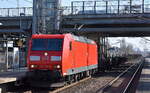 DB Cargo AG, Mainz mit ihrer  185 158-3  (NVR:  91 80 6185 158-3 D-DB ) und einem Ganzzug Drehgestell-Flachwagen mit Bewehrungsstahl beladen am 08.03.24 Durchfahrt Bahnhof