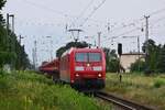 185 150-0 fährt mit Hydraulikschotterwagen durch Annaburg in Richtung Jessen.