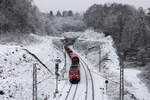 Am 11.01.2026 hat 185 168-2 mit ihrem Güterzug den Bildstock-Tunnel verlassen und wird in wenigen Augenblicken den Haltepunkt Friedrichsthal (Saar) Mitte durchfahren.