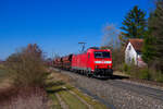 185 054 DB Cargo mit einem Schotterzug bei Postbauer-Heng Richtung Regensburg, 28.02.2022
