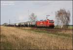 185 189 kommt mit einem Minerallzug aus Stendell nach Rhsa am rtchen Grfendorf bei Falkenberg/Elster vorbei, 16:00 Uhr am 30.03.09.