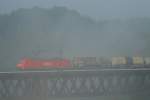 185 176 fhrt bei frhnebel Beratzhausen mit ein Gemischten Gterzug ber die Brcke.21.09.07