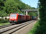 Im schnen Frhsommerwetter zieht die 185 163-3 ihren Gterzug unter der markanten Fugngerbrcke am Mnchner Nockherberg hindurch.