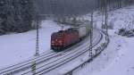 Eine BR 185 der DB ist am 28.01.2012 mit dem Hangartner / DB Schenker KLV aus Verona Q. E. nach Rostock Seehafen auf der Frankenwaldbahn zwischen Frtschendorf und Steinbach am Wald unterwegs.