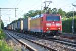 185 006-4 durchfhrt mit Containerwagen den Bahnhof von Dreieich-Buchschlag am Abend des 22.06.2012.