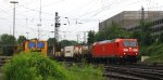 185 011-4 DB kommt aus Richtung Köln,Aachen-Hbf mit einem langen Containerzug aus Verona(I) nach Antwerpen-Combinant(B) und fährt in Aachen-West ein und auf dem Nebengleis steht eine Stopfmaschine und