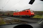 BR 185 117-9. Der Gterzug mit seiner feuerroten Lok durchfhrt das Fricktal im Kanton Aargau/Schweiz. Bei diesem Regenwetter bleibe ich lieber bequem im Auto sitzen, damit Kamera und ich trocken bleiben. Natrlich mu man erst eine geeignete Stelle zum Parken finden. Den Fensterrahmen habe ich bewut mit ins Bild  hereingenommen. 4.12.2006