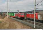 Zugbegegnung bei Neustadt an der Aisch. Während 185 219-3 ihren Containerzug Richtung Nürnberg zieht, ist 185 163-3 mit ihrem gemischten Güterzug Richtung Würzburg unterwegs. Die Aufnahme entstand am 12. März 2015.