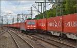 Unvermutet in Tarnfarbe. 185 224-3 vor rotem Containerzug. Hamburg Harburg, Juli 2015.