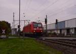 Mit einem langen Niederbordwagenzug am Haken durchfährt die 185 012-2 gerade den Bahnhof Groß-Gerau in Richtung Klein-Gerau.