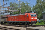 DB Lok 185 090-8 durchfährt den Bahnhof Muttenz.