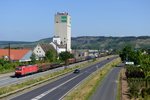 Am 20. Juli 2013 passiert 185 112 mit ihrem langen EZ 51887 von Mannheim Rbf nach Nürnberg Rbf das markante BayWa Lagerhaus und die Baumschule Müllerklein in Karlstadt.