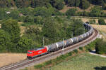 185 582 ex DB Cargo mit Kesseln kommt aus dem Esslinger Tunnel und wieder bereit sein mit der Kamera. Frühmorgens am 9 August 2026 am Bahnübergang Hagenacker im Altmühltal.