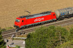 Akeem 185 582 ex DB Cargo mit Kesseln frühmorgens am 9 August 2026 am Bahnübergang Hagenacker im Altmühltal.